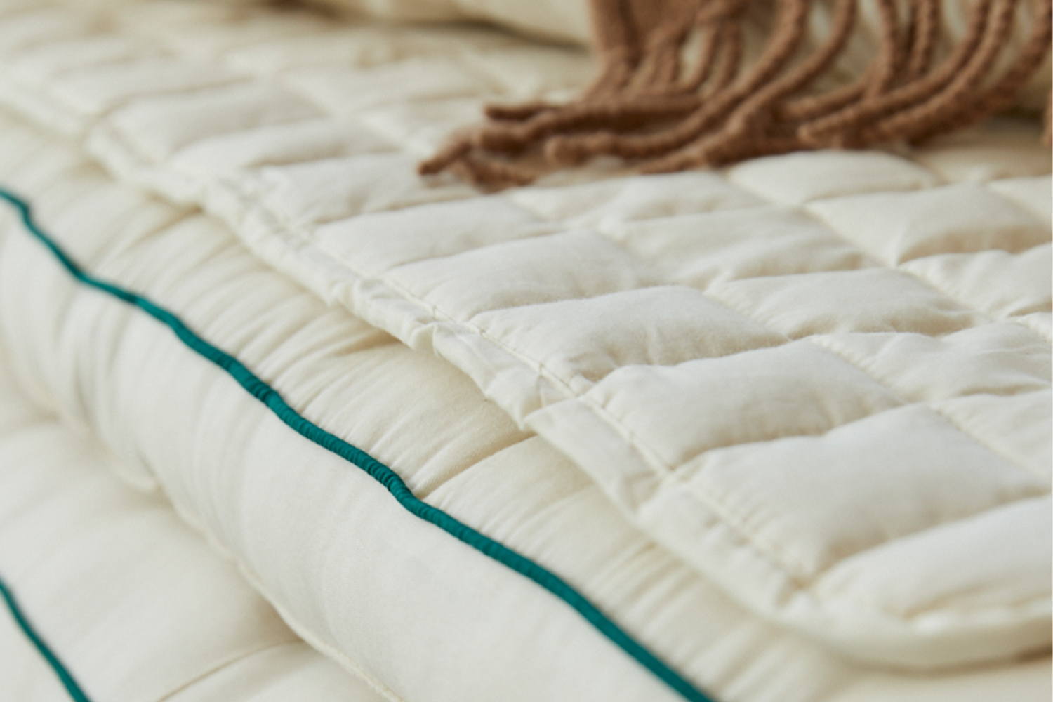 Detail of a quilted kapok mattress pad with no visible brand logo